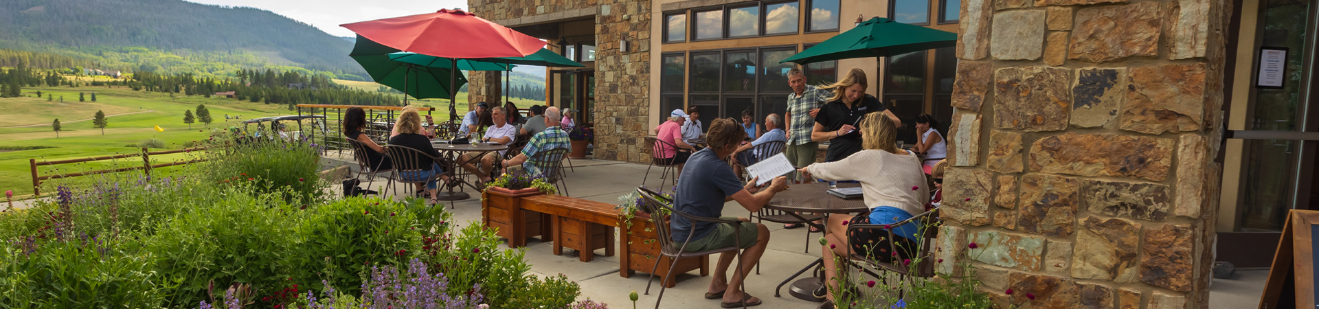 Guests enjoy al fresco dining at Bistro 28, the restaurant of Pole Creek Golf Club, with a panoramic view of the golf course in the background.